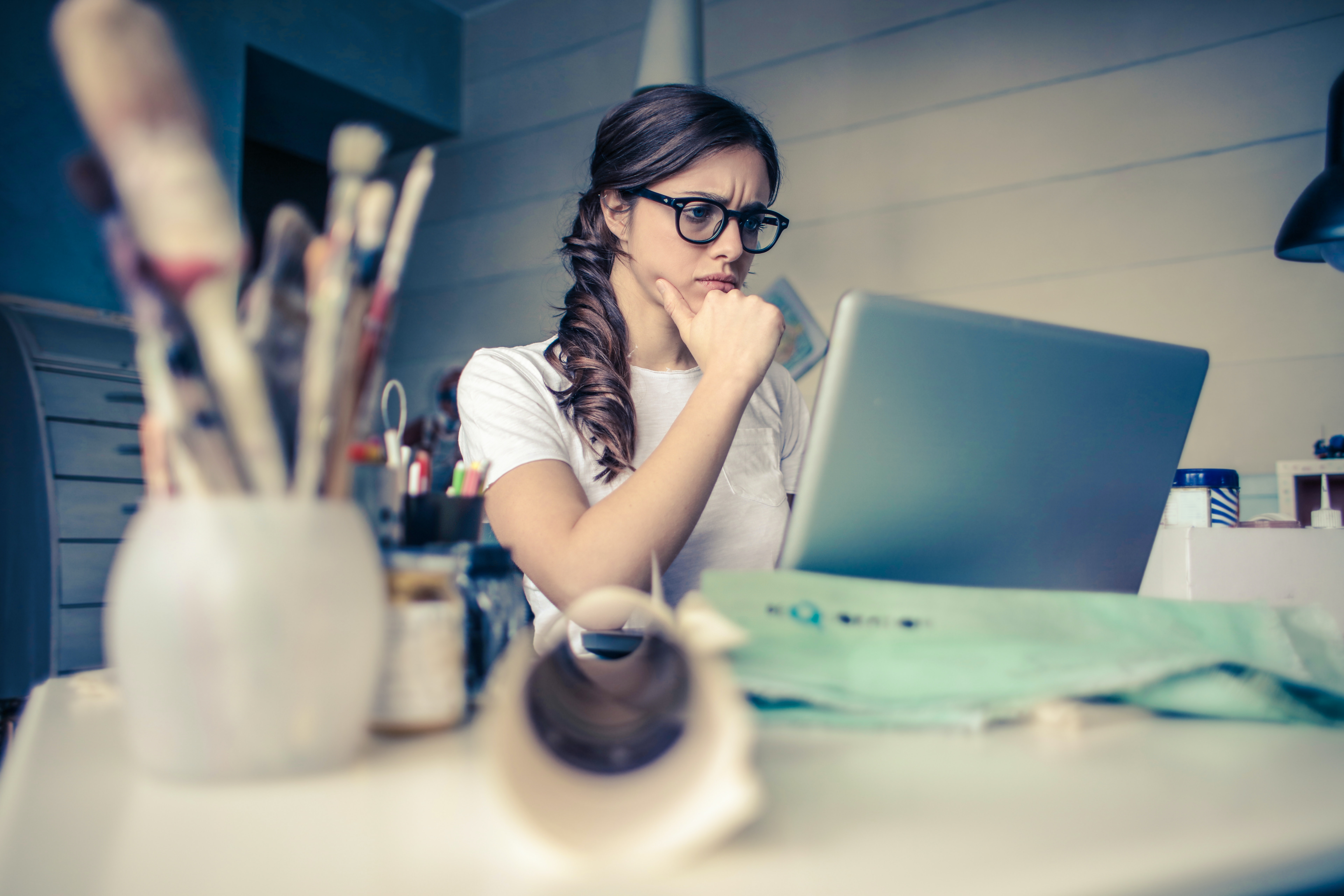 Foto de una mujer pensando frente a una computadora